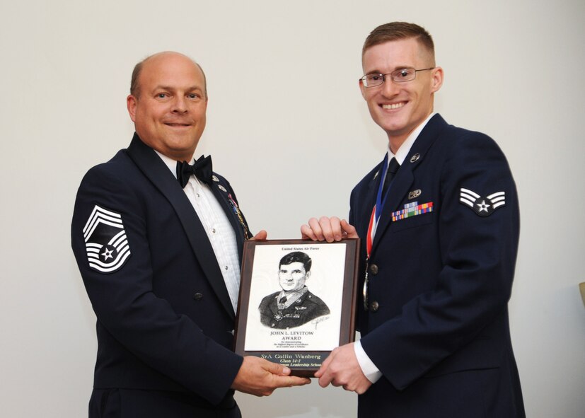 Senior Airman Collin Wanberg, 2nd Munitions Squadron, receives the John Levitow Award from Chief Master Sgt. Stephen Leburn, 2nd Operations Group, during the Airman Leadership School Class 14-1 Graduation on Barksdale Air Force Base, La., Nov. 21, 2013. (U.S. Air Force photo/Senior Airman Joseph A. Pagán Jr.)