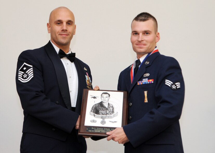 Senior Airman Glenn Cihak III, 2nd Aircraft Maintenance Squadron, receives the Commandant's Award from Master Sgt. David Bedner, 2nd Civil Engineer Squadron first sergeant, during the Airman Leadership School Class 14-1 Graduation on Barksdale Air Force Base, La., Nov. 21, 2013. (U.S. Air Force photo/Senior Airman Joseph A. Pagán Jr.)