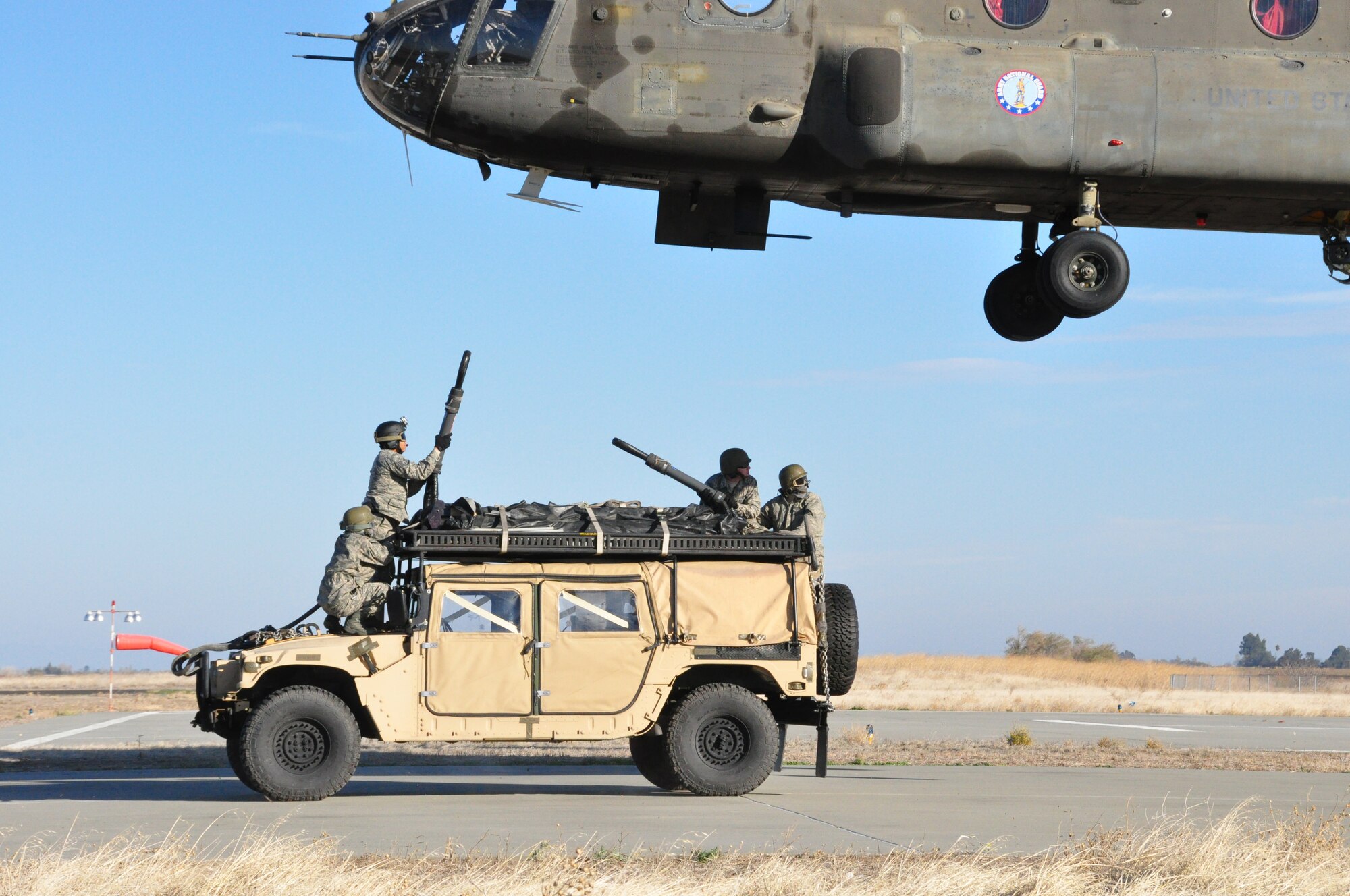 Airmen from 60th Aerial Port Squadron prepare to connect the sling on a humvee to a CH-47 Chinook Nov. 21 on an airfield in Rio Vista. (U.S. Air Force photo/Staff Sgt. Patrick Harrower)