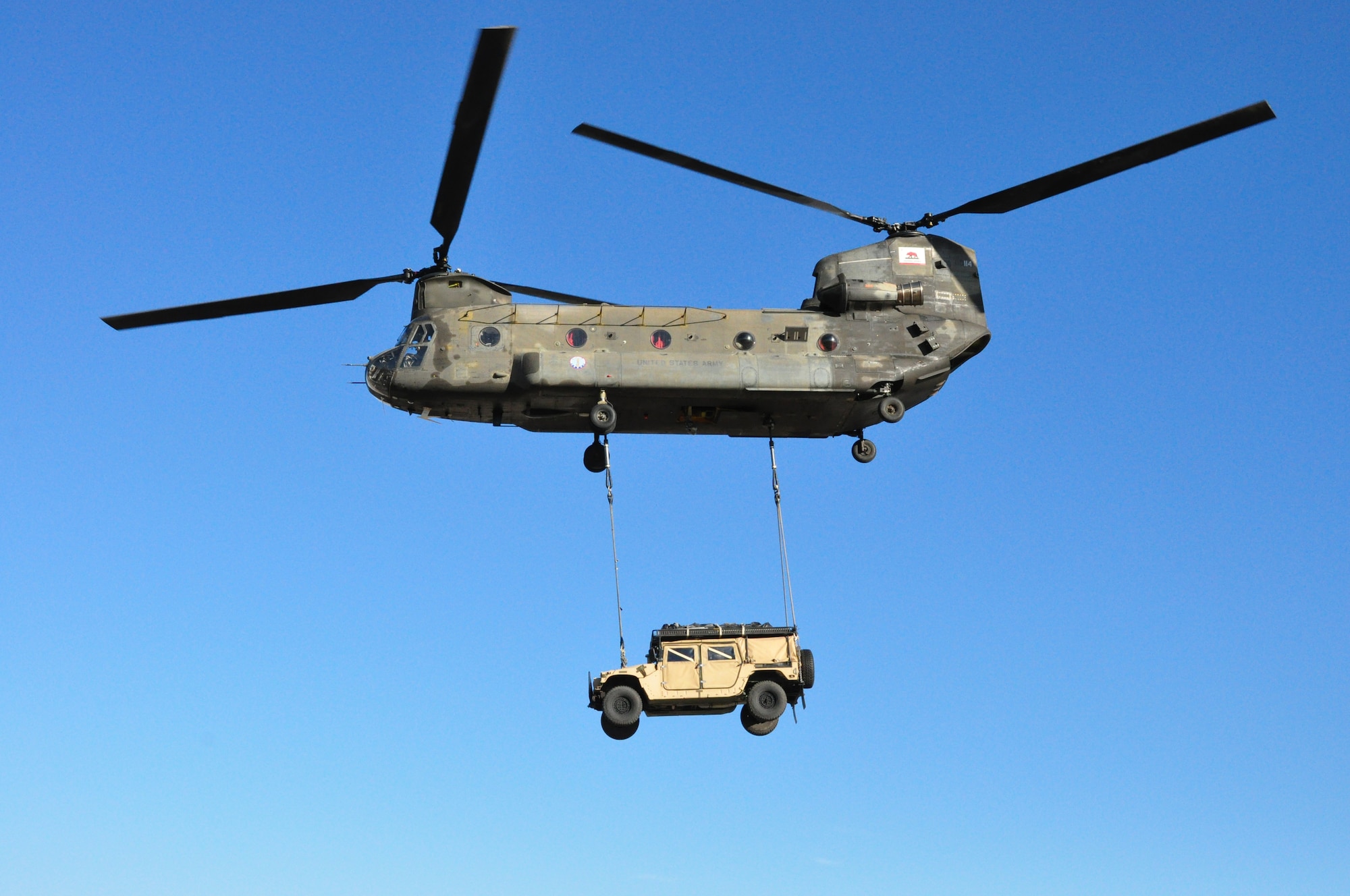 An Army National Guard CH-47 Chinook transports a Travis humvee via a cargo sling Nov. 21 over an airfield in Rio Vista. (U.S. Air Force photo/Staff Sgt. Patrick Harrower)