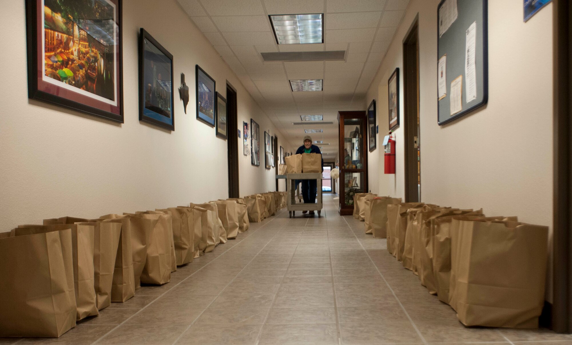 A food drive took place at the Airmen and Family Readiness Center here, so families could have the opportunity to enjoy a tasty holiday cheer Nov. 22-26. Around 7300 pounds of food and 249 turkeys were being prepared, as a gaggle of volunteers went around in a circle putting food supplies in bags. (U.S. Air force photo by Airman 1st Class Jelani Gibson) 