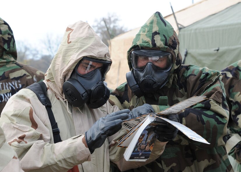 Post Attack Reconnaissance team members use an Airman's Manual during an Ability to Survive and Operate scenario on Barksdale Air Force Base, La., Nov. 21, 2013.  The PAR members marked and reported an unexploded ordnance during the ATSO to determine the parameters required for a cordon around it. (U.S. Air Force photo/Senior Airman Joseph A. Pagán Jr.)
