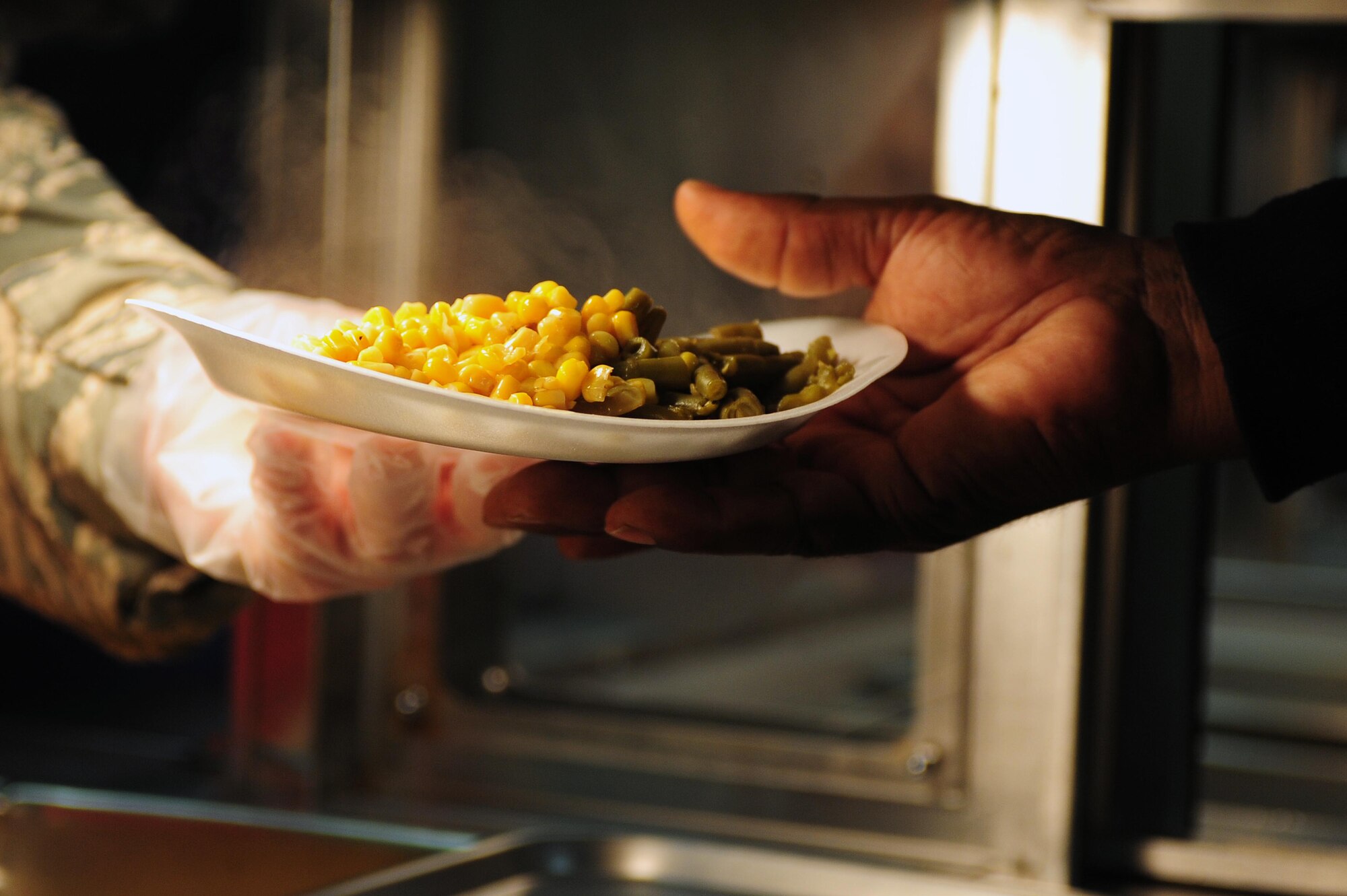 U.S. Air Force Chief Master Sgt. Jeffrey Craver, 4th Fighter Wing command chief, serves food to a community member in need of a meal while volunteering at a soup kitchen in Goldsboro, N.C., Nov. 27, 2013.  Airmen from the 4th Fighter Wing volunteered their time to serve more than 100 people in need meals the day before Thanksgiving.  (U.S. Air Force photo by Airman 1st Class John Nieves Camacho)