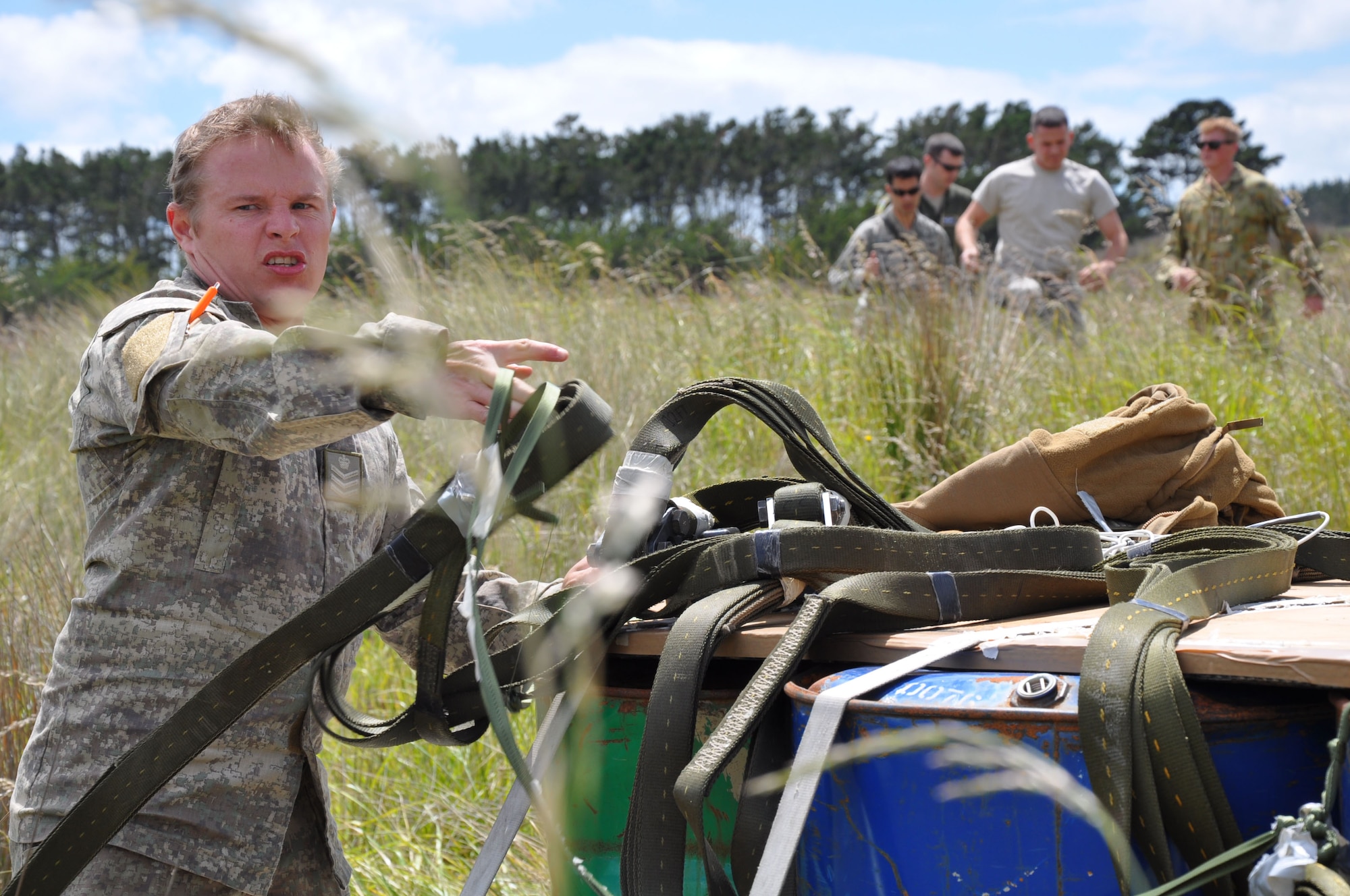 OHAKEA, New Zealand -- New Zealand Army Staff Sgt. Peter Baker, 5th Movements Co., begins recovering tactically-air-dropped cargo which landed just east of the drop zone during Exercise Kiwi Flag at the New Zealand Defence Force Raumi Drop Zone near Ohakea, New Zealand. Kiwi Flag is a multilateral Royal New Zealand Air Force-sponsored tactical airlift exercise comprising air assets from the USAF, RNZAF, RAAF, RSAF and French Armed Forces of New Caledonia. (U.S. Air Force photo by Senior Master Sgt. Denise Johnson/Released)