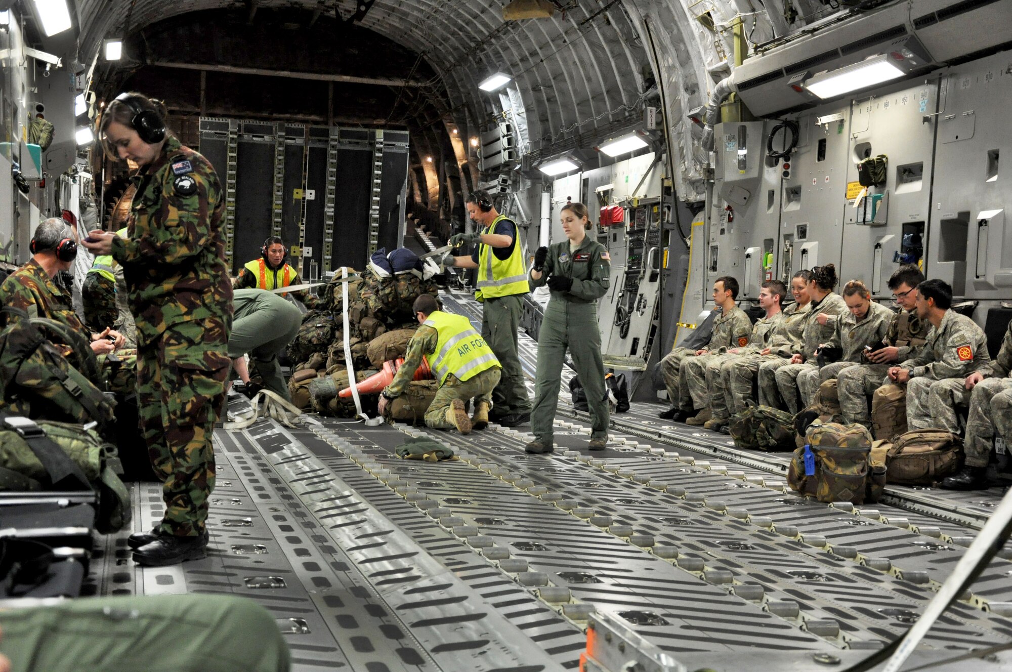 United States Air Force and Royal New Zealand Air Force airmen work together to load a U.S. Air Force C-17 Globemaster III in preparation for an aerial delivery and personnel transport during Exercise Kiwi Flag at RNZAF Base Ohakea, New Zealand, Nov. 21. The RNZAF and NZ Army personnel are being transported to New Zealand’s South Island in support of another exercise. Kiwi Flag is a multilateral RNZAF-sponsored tactical airlift exercise conducted in New Zealand. The Royal Australian Air Force, Republic of Singapore Air Force, and the French Armed Forces of New Caledonia also participated. Kiwi Flag personnel provided cargo and passenger airlift including tactical air drops to Exercise Southern Katipo, New Zealand Defence Force’s largest-ever multilateral joint force amphibious exercise with eight other nations participating. (U.S. Air Force Photo by Senior Master Sgt. Denise Johnson/Released)