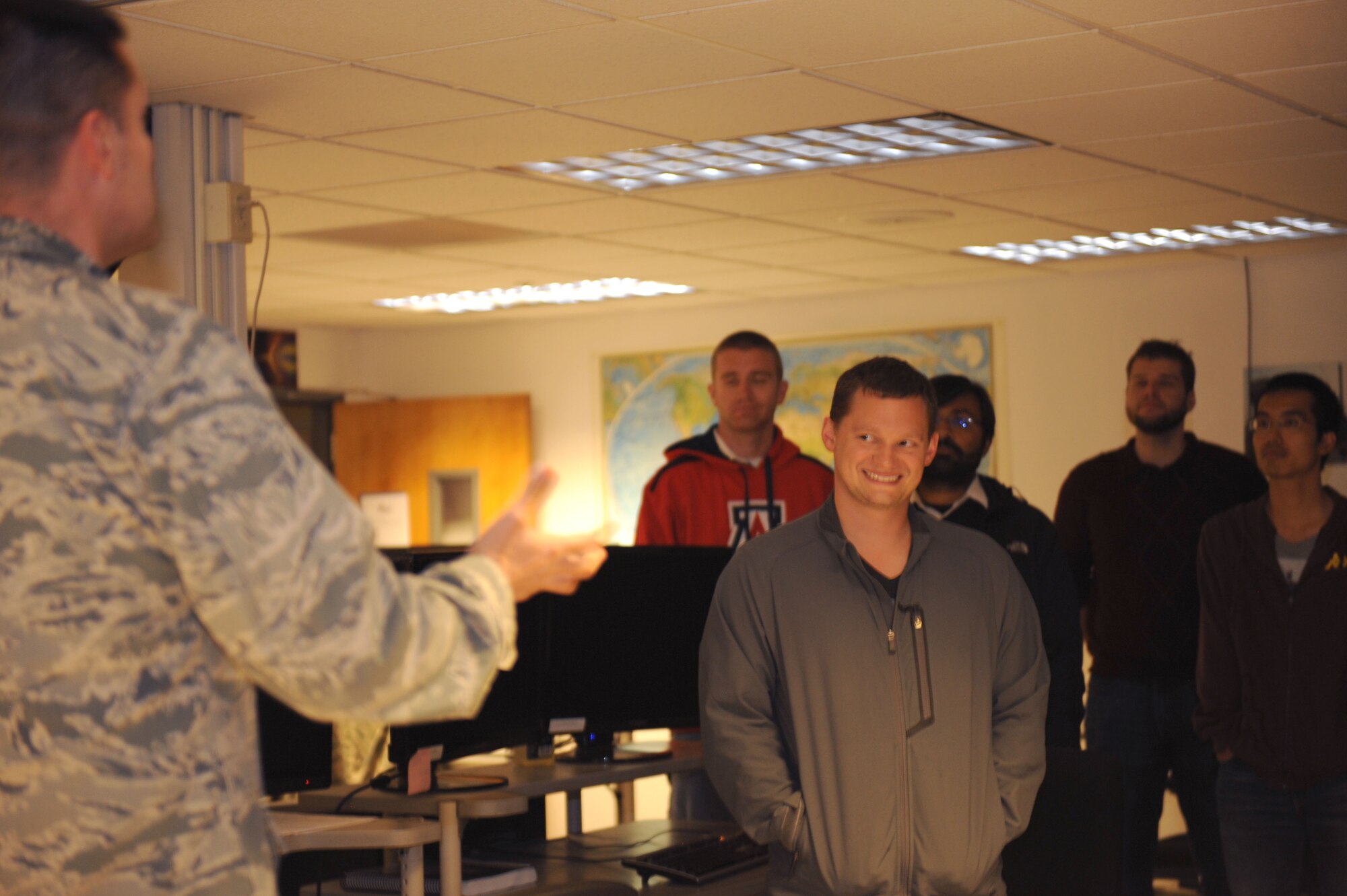 Kyle Davis, University of Arizona student, smiles during the question-and-answer portion of a tour at the 25th Operational Weather Squadron at Davis-Monthan Air Force Base, Ariz., Nov.22, 2013. Sixteen UA graduate and doctoral students from the Departments of Atmospheric Sciences, Geosciences and Planetary Sciences participated in the tour to learn how accurate forecasting affects military operations. (U.S. Air Force photo by Airman 1st Class Saphfire Cook/Released)
