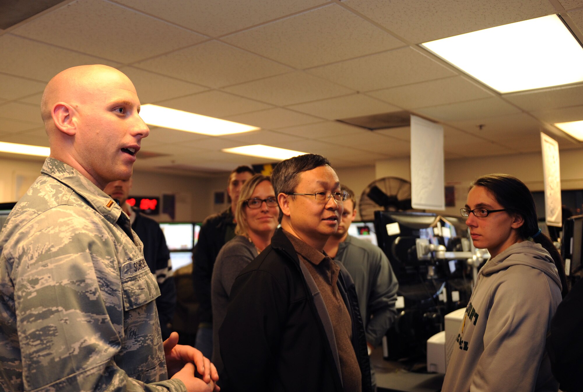 U.S. Air Force 2nd Lt. Dan Schreiber, 25th Operational Weather Squadron senior duty officer, talks with Dr. Xubin Zeng, University of Arizona Department of Atmospheric Sciences professor, and a group of his UA students during a tour at the 25th OWS at Davis-Monthan Air Force Base, Ariz., Nov.22, 2013. Zeng is the honorary commander for the 25th OWS and brought some of his Dynamic Meteorology students on base for a tour of the weather squadron. (U.S. Air Force photo by Airman 1st Class Saphfire Cook/Released)