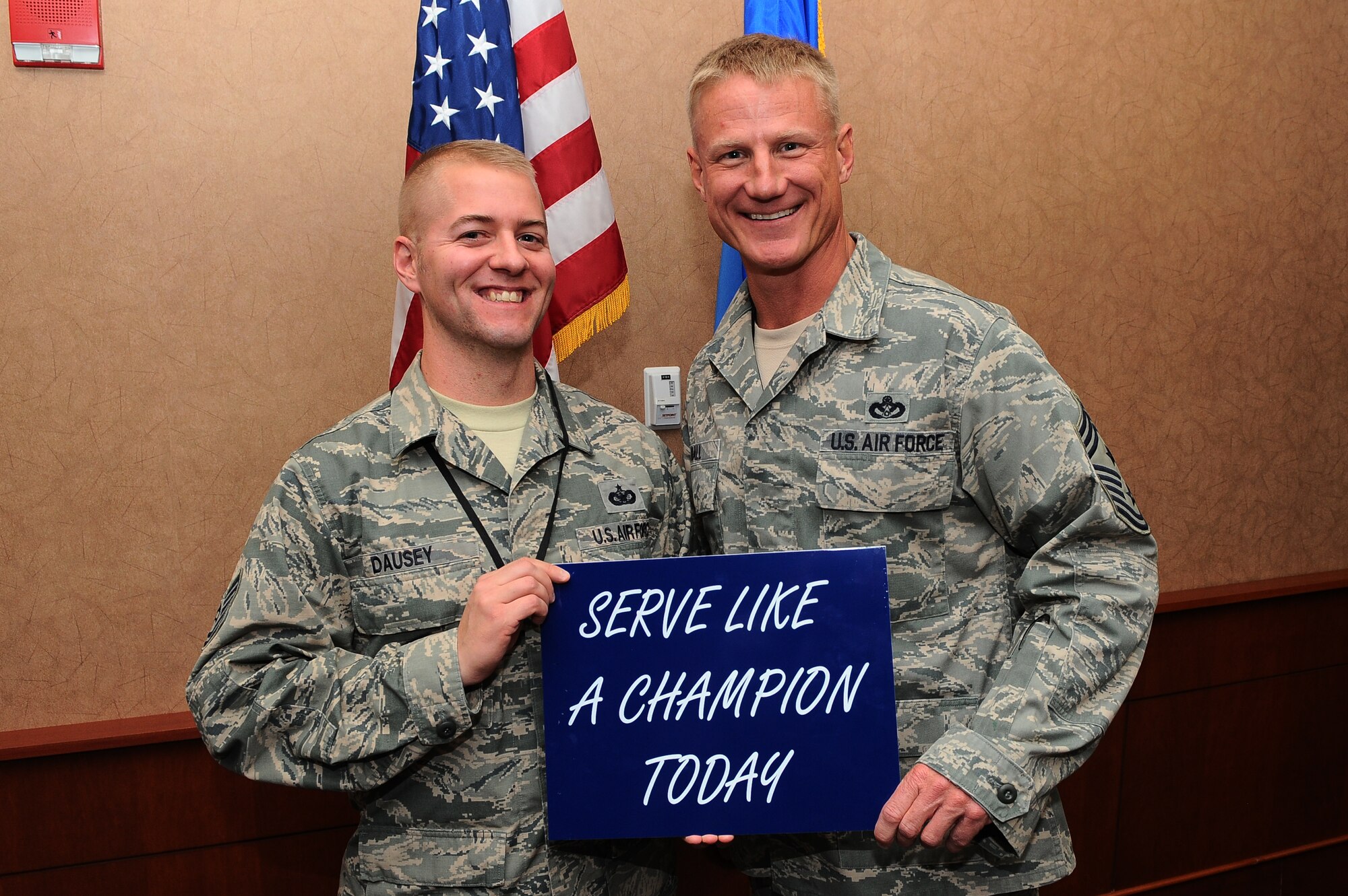 Tech. Sgt. Jeffrey Dausey, 460th Space Wing Antiterrorism Office, receives the “Serve Like A Champion” Award from Chief Master Sgt. Craig S. Hall, 460th SW command chief, Nov. 22, 2013, at the 460th SW headquarters building on Buckley Air Force Base, Colo. Dausey received this award for demonstrating excellent morals and service. This is the third award Hall has given that rewards and encourages Team Buckley members to serve like a champion. (U.S. Air Force photo by Senior Airman Phillip Houk/Released)