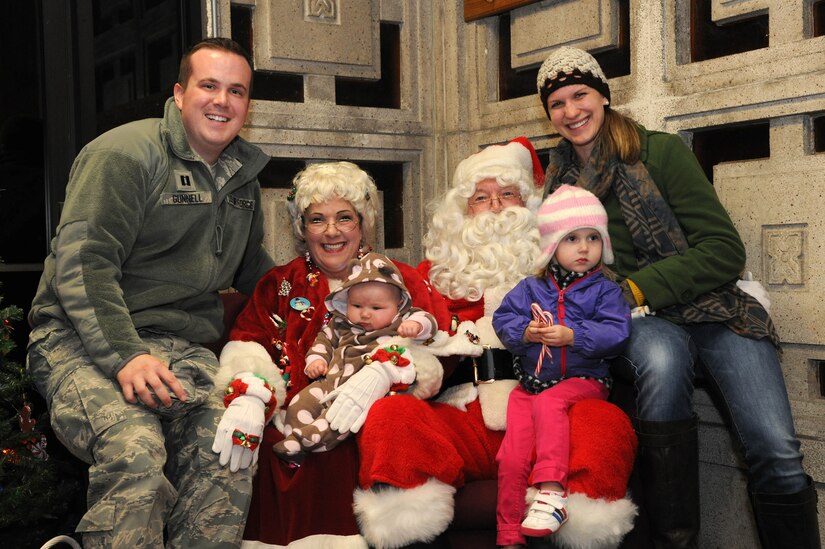Capt. Chase Gunnell, 11th Wing Assistant Staff Judge Advocate, and his family pose for a photo with Santa Claus and Mrs. Claus during the annual Christmas tree and Menorah lighting ceremony at Joint Base Andrews, Md., Nov. 26, 2013. During the night children were given the chance to talk to Santa and tell him what they wanted for Christmas. (U.S. Air Force photo/Airman 1st Class Ryan J. Sonnier)