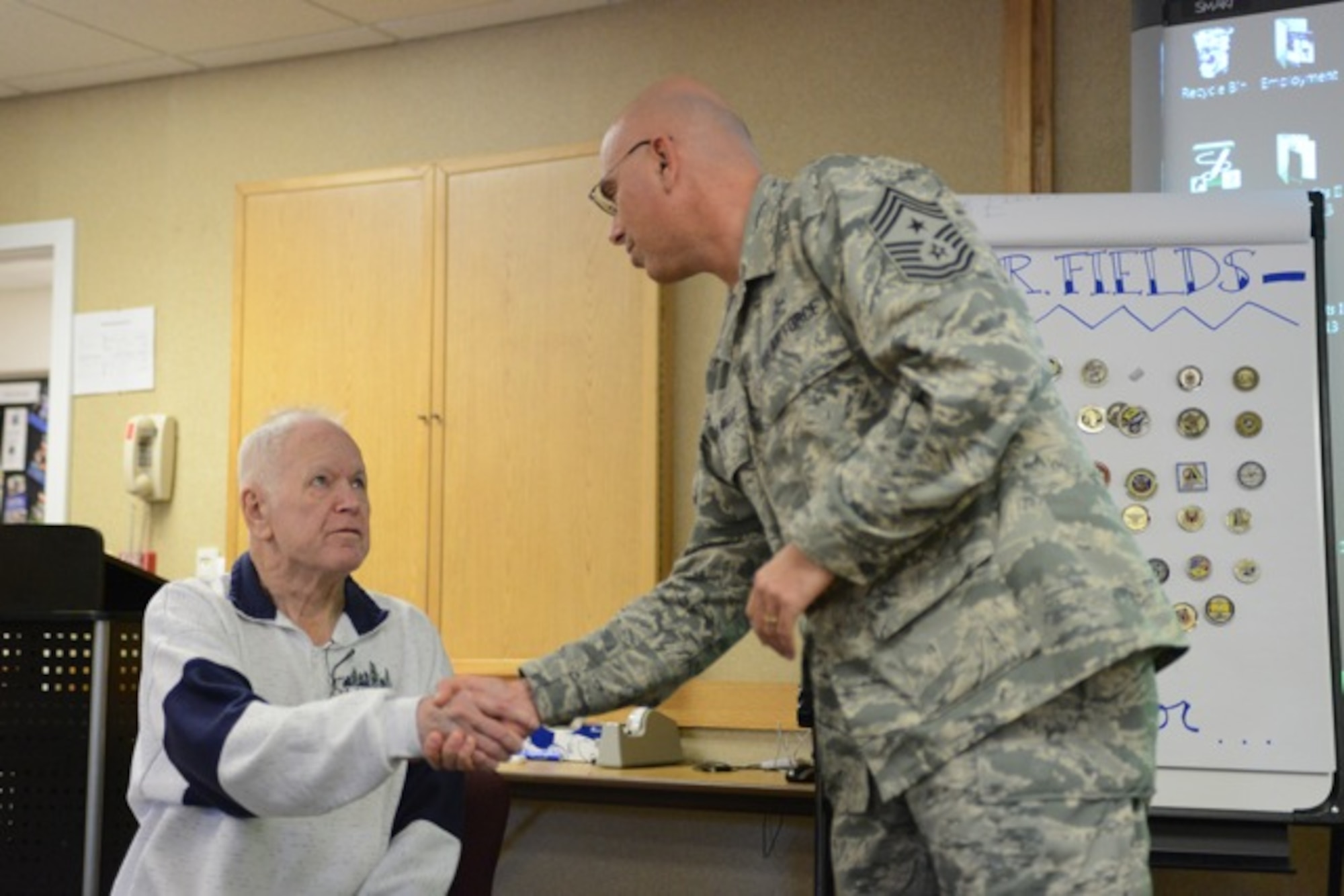 U. S. Air Force Chief Master Sgt. Alex del Valle, 366th Fighter Wing command chief,  coins Mr. Fields, the father of a 366th Security Forces Squadron Defender Nov 27, 2013, at Mountain Home Air Force Base, Idaho. Defenders and members of the Airmen and Fanmily Readiness Center came together to show appreciation for Fields' service as he was recently the victim of a burglery and every coin he received throughout his career was stolen. (U.S. Air Force photo by Senior Airman Benjamin Sutton/Released) 