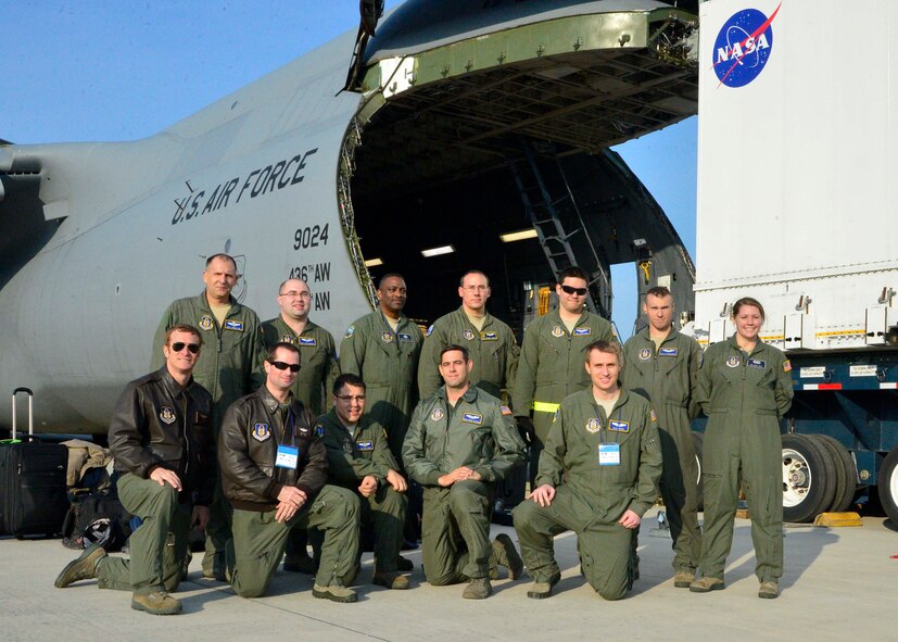 Aircrew from the 709th Airlift Squadron and crew chiefs from the 512th Maintenance Group pose for a group shot following the safe unload of the Global Precipitation Measurement Satellite Nov. 24, 2013, at Kitakyushu Airport in Japan. The crew worked hand-in-hand with NASA officials to ensure the delicate cargo was properly cared for during transport. (U.S. Air Force photo/Tech. Sgt. Jeremy Larlee)