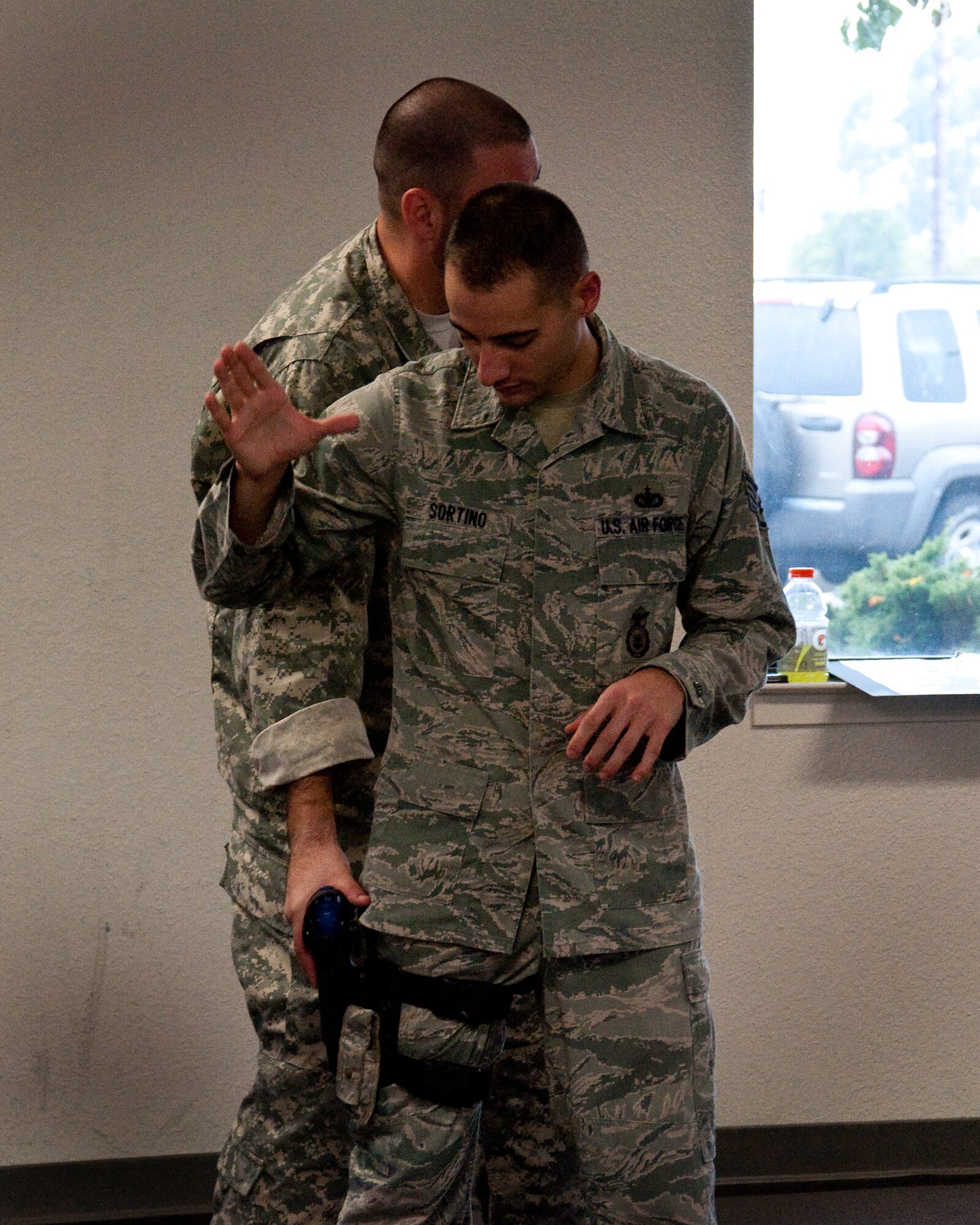 U.S. Air Force Staff Sgt. Michael Sortino, 60th Security Forces Squadron assistant instructor, demonstrates proper weapons retention techniques during an Air Force combatives course Nov. 20, 2013, at Travis Air Force Base, Calif. As a requirement, security forces Airmen must have an initial 20-hour training course and an annual ten hour refresher course. (U.S. Air Force photo by Senior Airman Charles V. Rivezzo)