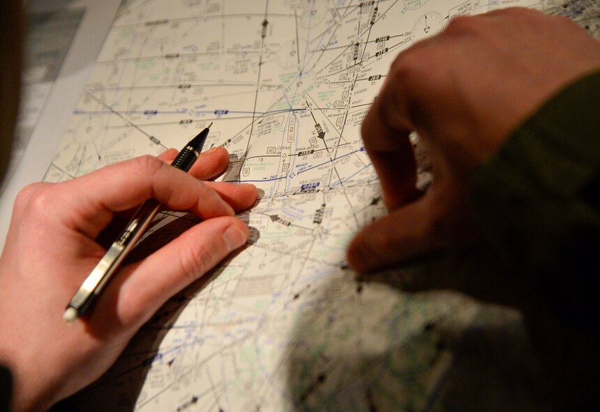Air Force Reserve 2nd Lt. Ryan Moate, 709th Airlift Squadron pilot, uses a map of flight paths at Joint Base Andrews, Md., Nov. 20, 2013, to prepare for a trip from the base to Kitakyushu Airport in Japan. The trip took 16 hours as the C-5M Super Galaxy worked against extremely strong head winds. (U.S. Air Force photo/Tech. Sgt. Jeremy Larlee)