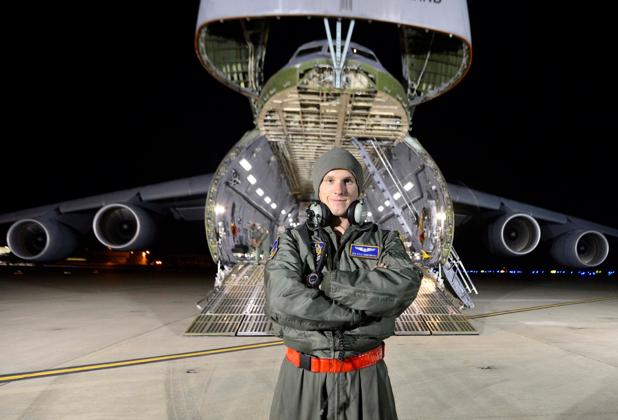 Air Force Reserve Senior Airman Kyle Klinkenborg, 709th Airlift Squadron loadmaster, poses in front of a C-5M Super Galaxy following the load of the Global Precipitation Measurement Satellite's support equipment Nov. 20, 2013 at Joint Base Andrews, Md. Once the satellite was on board, loadmasters properly secured it to ensure it was not damaged. (U.S. Air Force photo/Tech. Sgt. Jeremy Larlee)