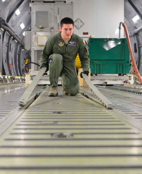 Air Force Reserve Senior Airman Travis Shea, 709th Airlift Squadron loadmaster student, prepares the cargo floor of a C-5M Super Galaxy for the Global Precipitation Measurement Satellite's support equipment Nov. 21, 2013 at Joint Base Andrews, Md. The mission to deliver the satellite to Japan was Shea's first ever. (U.S. Air Force photo/Tech. Sgt. Jeremy Larlee)