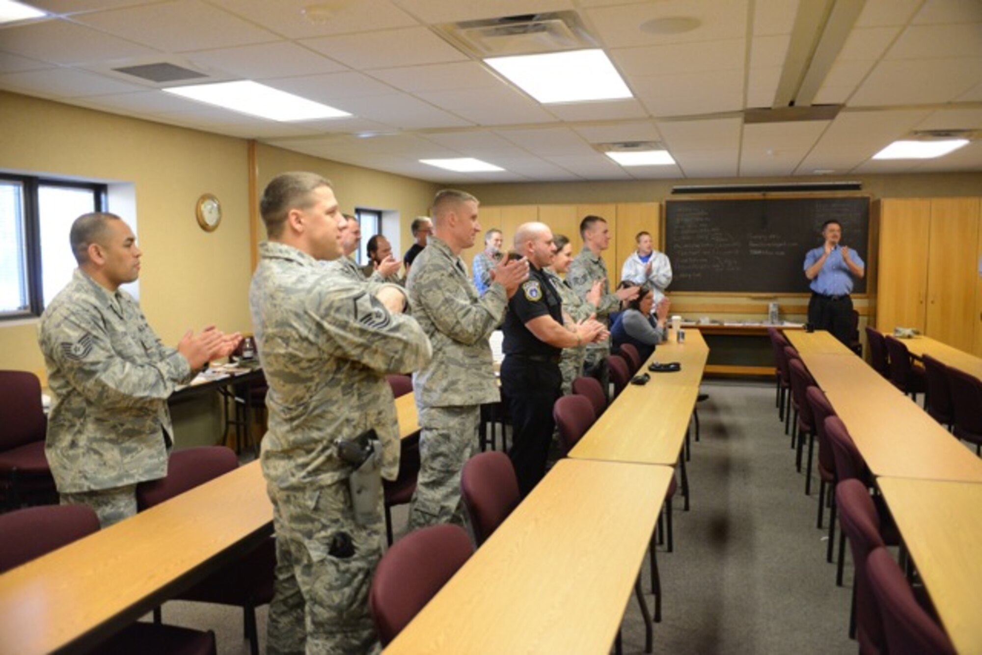 Members from the 366th Fighter Wing applaud during a re-coining ceremony Nov.27, 2013, at Mountain Home Air Force Base, Idaho. Gunfighters came together to take care of one of their own who was the victim of a home burglery. (U.S. Air Force photo by Senior Airman Benjamin Sutton/Released) 