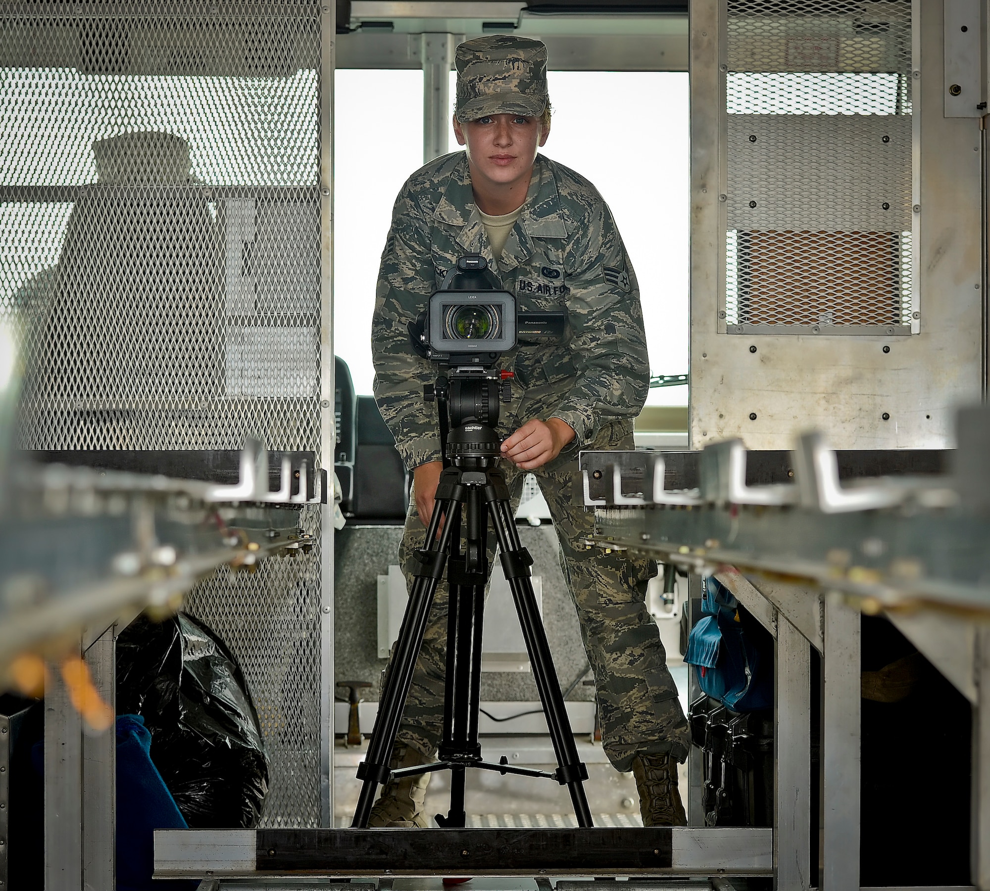 Senior Airman Laura Beckley, Air Force Mortuary Affairs Operations broadcaster, readies her equipment before a dignified transfer at Dover Air Force Base, Del., on August 22, 2013. Back in July, Beckley was deployed to Dover to assume the roles as a member of the AFMAO documentation team. (U.S. Air Force Photo by David Tucker/Released)