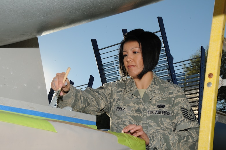 U.S. Air Force Tech. Sgt. Angela Perez, 161st Air Refueling Wing Maintenance Group commanders support staff, paints a gun barrel from the USS Arizona as part of the Arizona World War II memorial “Guns to Salute the Fallen” at Wesley Bolin Memorial  Park, Phoenix, Nov.26, 2013. The memorial is a tribute to the fallen service members of World War II, which presents historic gun barrels from the USS Arizona and the USS Missouri, representing the beginning and end of World War II. (U.S. Air National Guard Photo by Technical Sgt. Michael Matkin/Released)