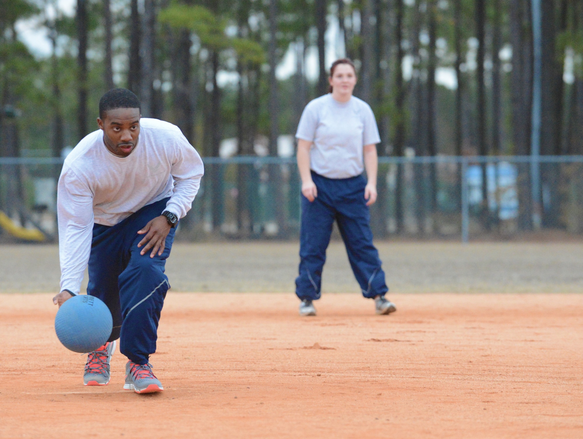 U.S. Air Force Staff Sgt. Joshua Lewis, 20th Fighter Wing legal office NCO in charge of non-judicial punishment, pitches the ball as Airman 1st Class Kelsey White, 20th FW legal office military justice paralegal, stands ready during a kickball game between the 20th FW legal office and U.S. Army Central judge advocates at Shaw Air Force Base, S.C., Nov. 25, 2013. The teams gathered for a morale-boosting game to augment social interactions between the services. (U.S. Air Force photo by Airman 1st Class Diana M. Giannetti/Released)