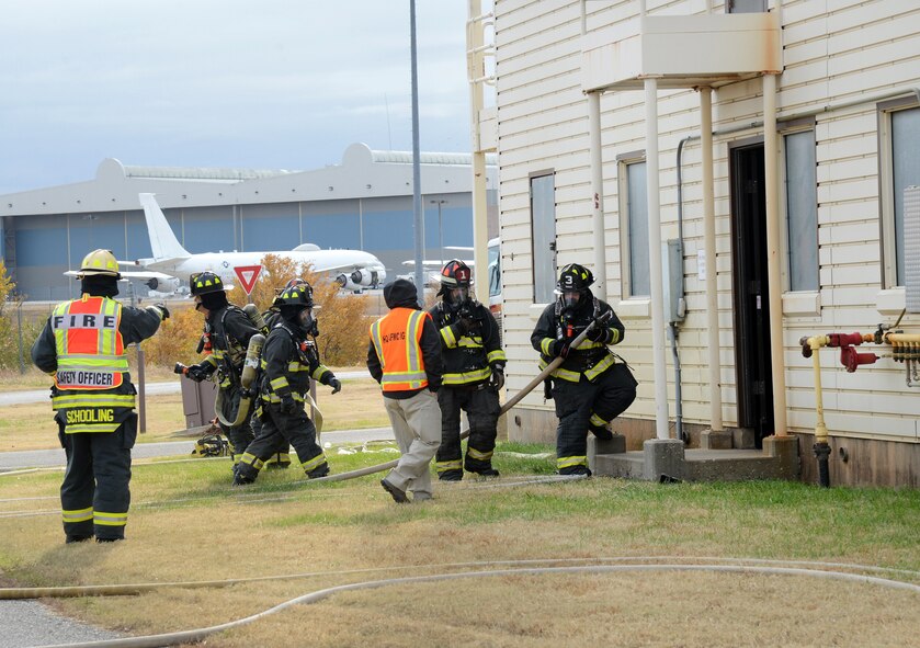 Inspectors observe Tinker Fire and Emergency Services personnel during their Consolidated Unit Inspection last Thursday. Fire crews responded to a staged initial fire attack at Bldg. 1124, a two-story structure used for training purposes. The inspectors observed the initial coordination of the crews, and how they deployed and advanced lines into the structure. They watched the search crew clear the building, the vent crew release heated gases and combustibles and the rapid intervention team protecting the other crews. This was one of many inspections taking place around base in Air Force Materiel Command, Air Combat Command and Air Force Reserve Command units last week. (Air Force photo by Kelly White)