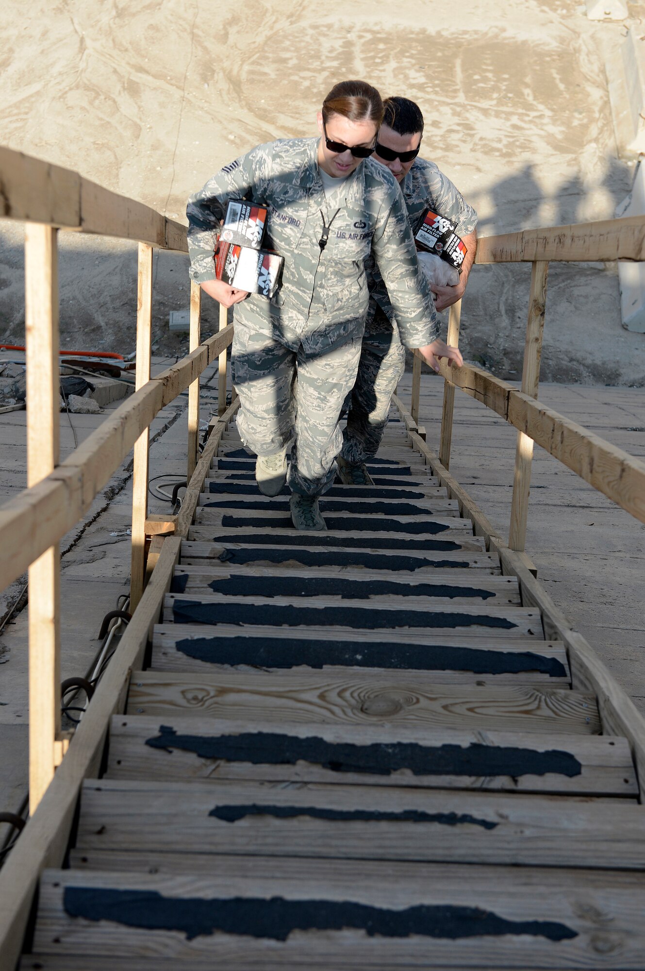 Tech. Sgt. April Stanford and Staff Sgt. David Glowacki (left to right), 386th Expeditionary Operations Support Squadron, weather flight technicians, ascend stairs to perform preventative maintenance on the tactical meteorological equipment here, Nov. 21, 2013. Stanford is deployed out of the 19th Operations Support Squadron, Little Rock Air Force Base, Jacksonville, Ark., and is a native of Arlington, Texas.  Glowacki is deployed out of the 437th Operations Support Squadron, Joint Base Charleston, Charleston, S.C., and is a native of Buffalo, N. Y.  (U.S. Air Force photo by Master Sgt. Christopher A. Campbell)