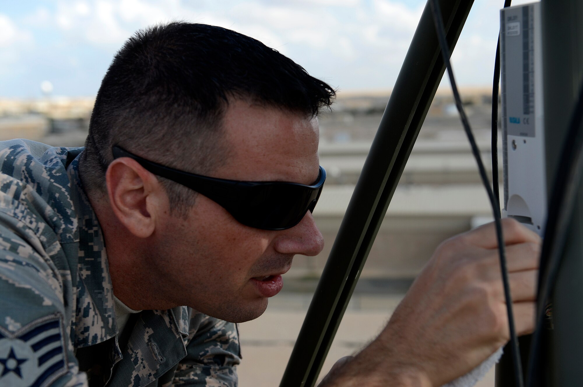 Staff Sgt. David Glowacki, 386th Expeditionary Operations Support Squadron, weather technician, cleans off the logger and pressure sensor on the Tactical Meteorological Observing System, TMQ-53 during quarterly preventative maintenance inspection here, Nov. 21, 2013. Glowacki is deployed out of the 437th Operations Support Squadron, Joint Base Charleston, Charleston, S.C., and is a native of Buffalo, N. Y. (U.S. Air Force photo by Master Sgt. Christopher A. Campbell)