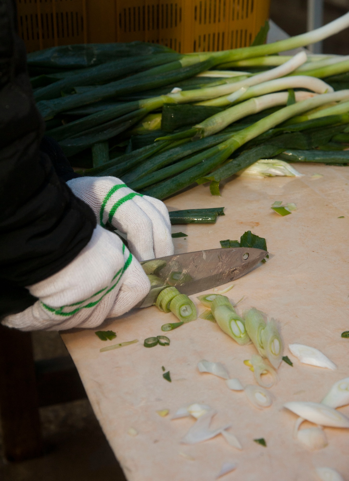 A Wolf Pack Airman cuts green onion, Nov. 27, 2013, at a Women’s Volunteer Center that provides kimchee for the homeless and needy in Gunsan, Republic of Korea. The Wolf Pack focused on the well-being of others as part of becoming resilient. (U.S. Air Force photo by Staff Sgt. Jessica Haas/Released) 