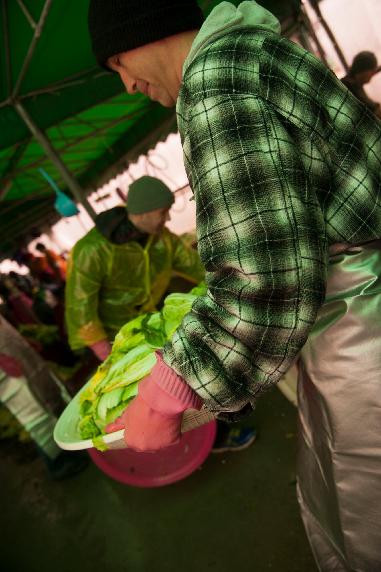 Tech. Sgt. Tim White, 8th Maintenance Squadron, carries a tray of cabbage, Nov. 27, 2013, at a Women’s Volunteer Center that provides kimchee for the homeless and needy in Gunsan, Republic of Korea. The Wolf Pack focused on the well-being of others as part of becoming resilient. (U.S. Air Force photo by Staff Sgt. Jessica Haas/Released) 