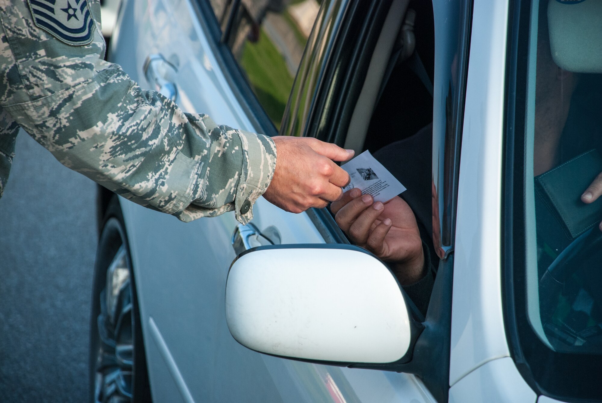 The 18th Wing's senior enlisted hand out leaflettes with phone numbers to taxis to raise awarness about having a plan to get home safely instead of drinking and driving this Thanksgiving holiday weekend Nov. 27, 2013, at Gate One on Kadena Air Base, Japan. They wished everyone a safe and happy Thanksgiving and reminded them to "Arrive Alive, Don't Drink and Drive." Taxis are available on and off base, and service members can also call Airmen Against Drunk Driving at 098-961-2233 or DSN 634-AADD. (U.S. Air Force photo by Alexy Saltekoff)