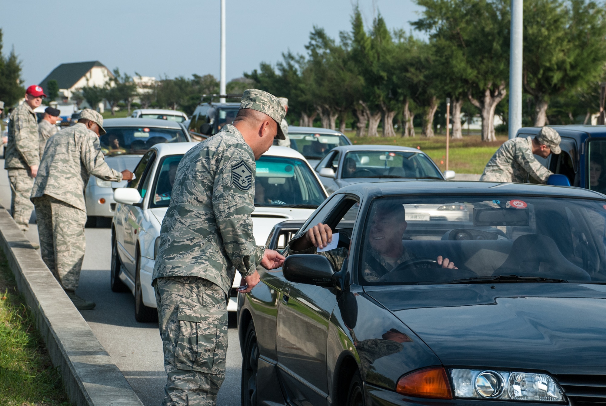 The 18th Wing's senior enlisted hand out leaflettes with phone numbers to taxis to raise awarness about having a plan to get home safely instead of drinking and driving this Thanksgiving holiday weekend Nov. 27, 2013, at Gate One on Kadena Air Base, Japan. Their message was simple, "Arrive Alive, Don't Drink and Drive." Taxis are available on and off base, and service members can also call Airmen Against Drunk Driving at 098-961-2233 or DSN 634-AADD. (U.S. Air Force photo by Alexy Saltekoff)