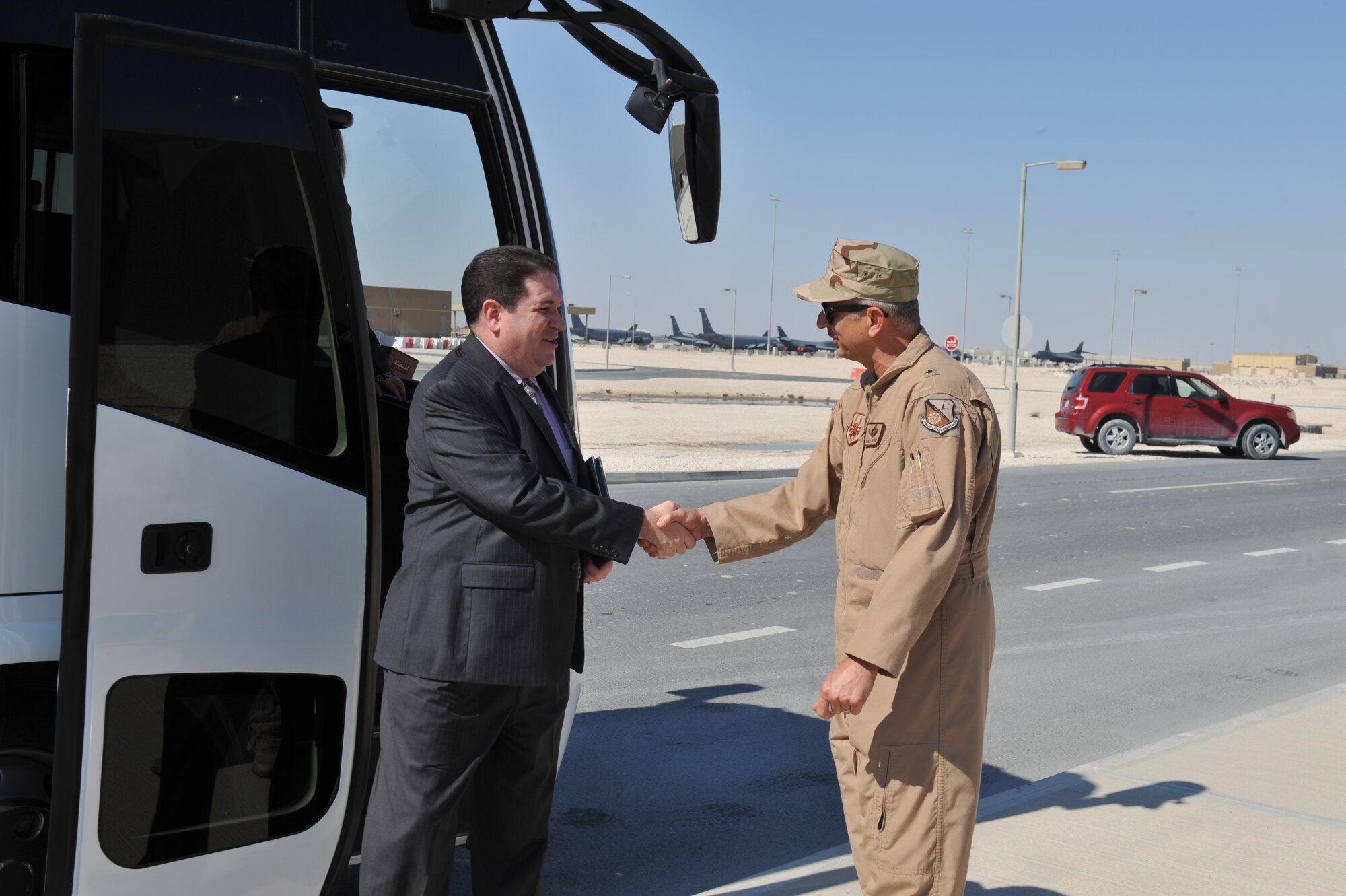 Ed McDonald (R-NC), chief of staff and press secretary for Congressman Howard Coble, shakes hands with Brig. Gen. Roger Watkins, 379th Air Expeditionary Wing commander, during a visit to the 379th AEW in Southwest Asia Nov. 25, 2013. McDonald and other congressional delegates received an overview of the 379th AEW mission and learned about the host nation in terms of economic, cultural and strategic position. (U.S. Air Force photo/ Master Sgt. David Miller)