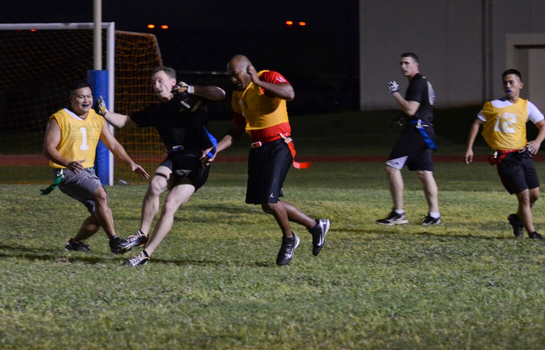 Shane Szymczak, 94th Army Air and Missile Defense Command, tries to evade defenders during an intramural flag football game Nov. 25, 2013, on Andersen Air Force Base, Guam. The 94th AAMDC defeated 22nd Space Operations Squadron Detachment 5, 40-0. (U.S. Air Force photo by Senior Airman Marianique Santos/Released)