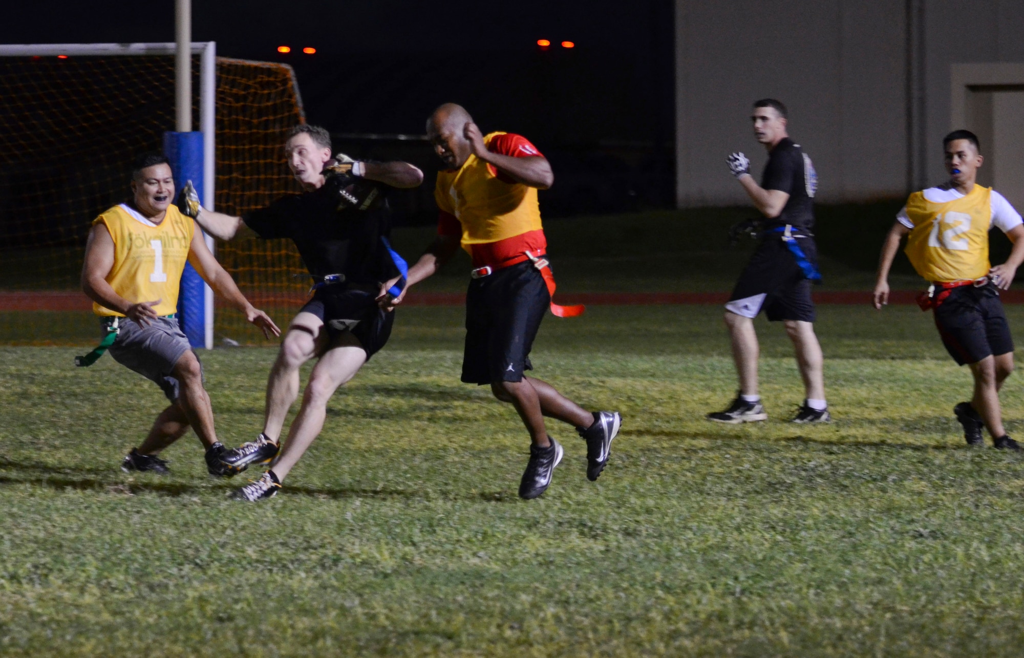 Shane Szymczak, 94th Army Air and Missile Defense Command, tries to evade defenders during an intramural flag football game Nov. 25, 2013, on Andersen Air Force Base, Guam. The 94th AAMDC defeated 22nd Space Operations Squadron Detachment 5, 40-0. (U.S. Air Force photo by Senior Airman Marianique Santos/Released)