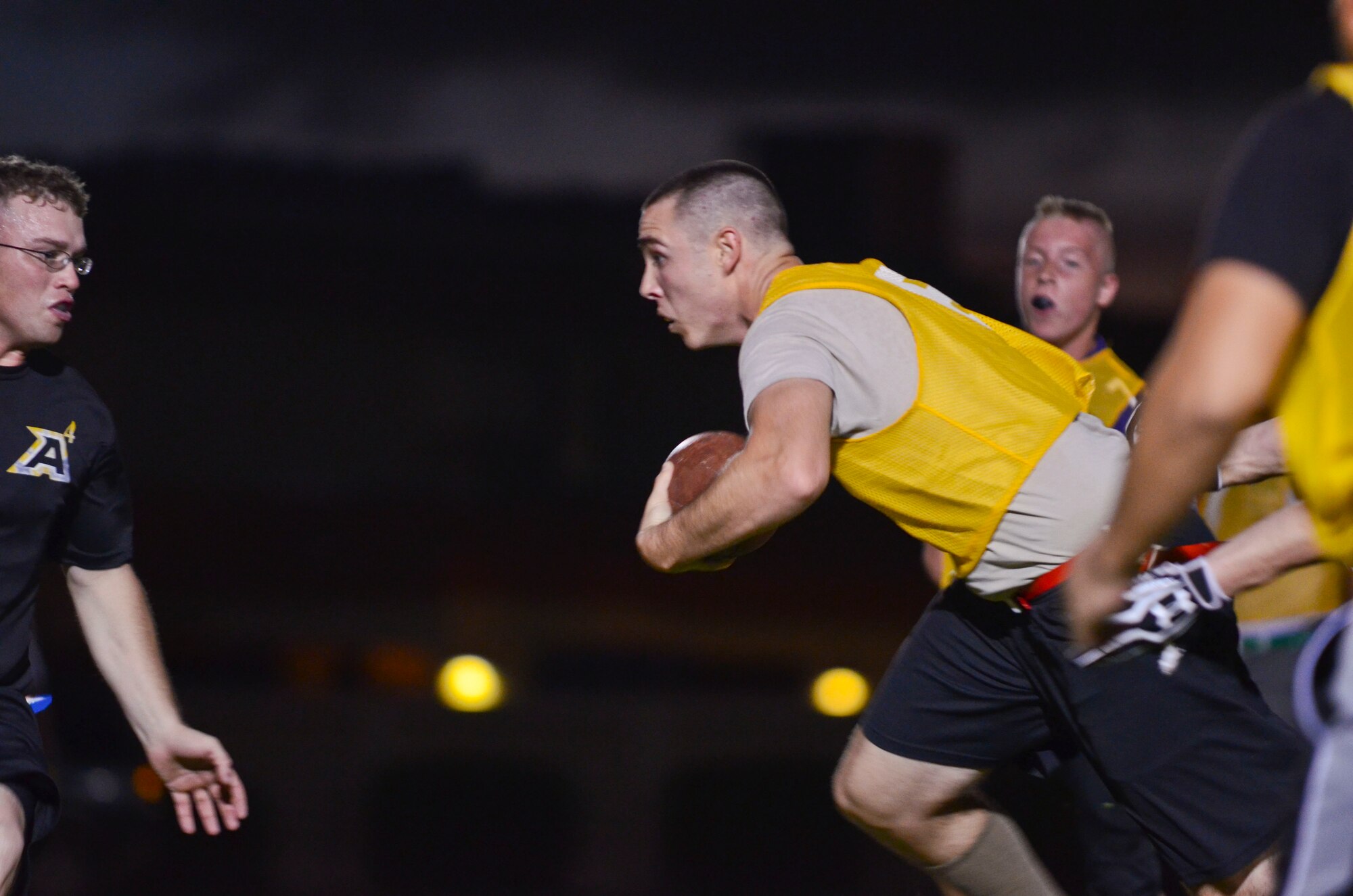 Mark Massey, 22nd Space Operations Squadron Detachment 5, runs past other players during an intramural flag football game Nov. 25, 2013, on Andersen Air Force Base, Guam. 94th Army Air and Missile Defense Command defeated 22nd SOPS Det 5, 40-0. (U.S. Air Force photo by Senior Airman Marianique Santos/Released)