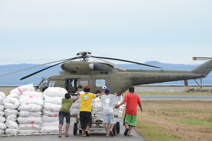 Volunteers at Tacloban Airport prepare to load a Philippine Air Force helicopter with relief supplies destined for forward delivery in the Tacloban region in support of Operation Damayan, Nov. 23, 2013. (U.S. Air Force photo by 2nd Lt. Jake Bailey/Released)