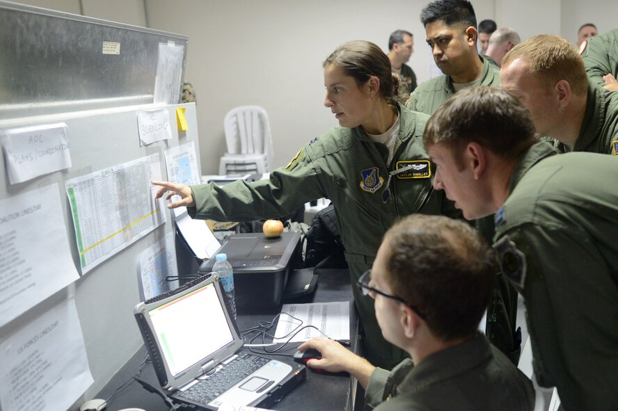 Capt. Taylor Rigollet, center, Air Component Coordination Element air liaison, briefs fellow members of the ACCE during Operation Damayan at Camp Aguinaldo, Manila, Nov. 23, 2013. Rigollet is deployed from the 36th Airlift Squadron, Yokota Air Base, Japan. (U.S. Air Force photo by 2nd Lt. Jake Bailey/Released)