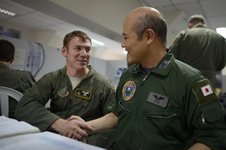 Capt. Dan Pallister, left, Air Component Coordination Element air liaison, shakes hands with Lt. Col. Masakazu Ito, Japan Air-Self-Defense Force, during Operation Damayan at Camp Aguinaldo, Manila, Nov. 23, 2013. Pallister is deployed from the 36th Airlift Squadron, Yokota Air Base, Japan. (U.S. Air Force photo by 2nd Lt. Jake Bailey/Released)