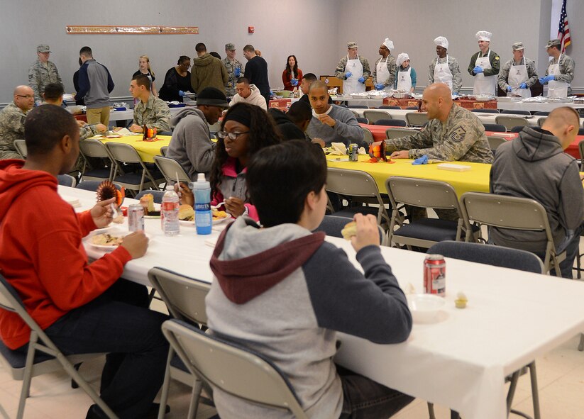 Airmen begin to eat at the start of a Thanksgiving luncheon for dorm Airmen on Barksdale Air Force Base, La., Nov. 28, 2013. The meal was held for more than 100 dorm Airmen unable to go home for Thanksgiving and the Airmen who were on duty during the holiday. (U.S. Air Force photo/Staff Sgt. Amber Corcoran)