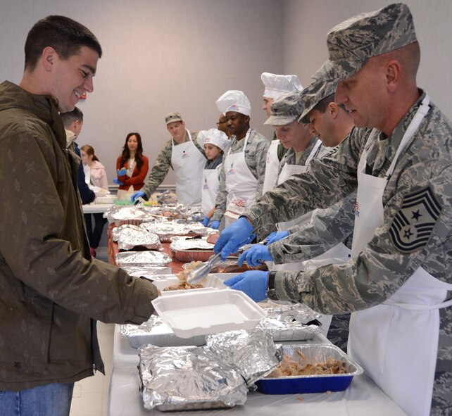 Airmen are served turkey and ham by base leadership during a Thanksgiving luncheon for dorm Airmen on Barksdale Air Force Base, La., Nov. 28, 2013. Prior to the start of the Thanksgiving luncheon, to-go boxes were put together and runners were sent to hand deliver the boxes to the shift workers and security forces Airmen including the Airmen working at the Fire Department, lodging and command post. (U.S. Air Force photo/Staff Sgt. Amber Corcoran)