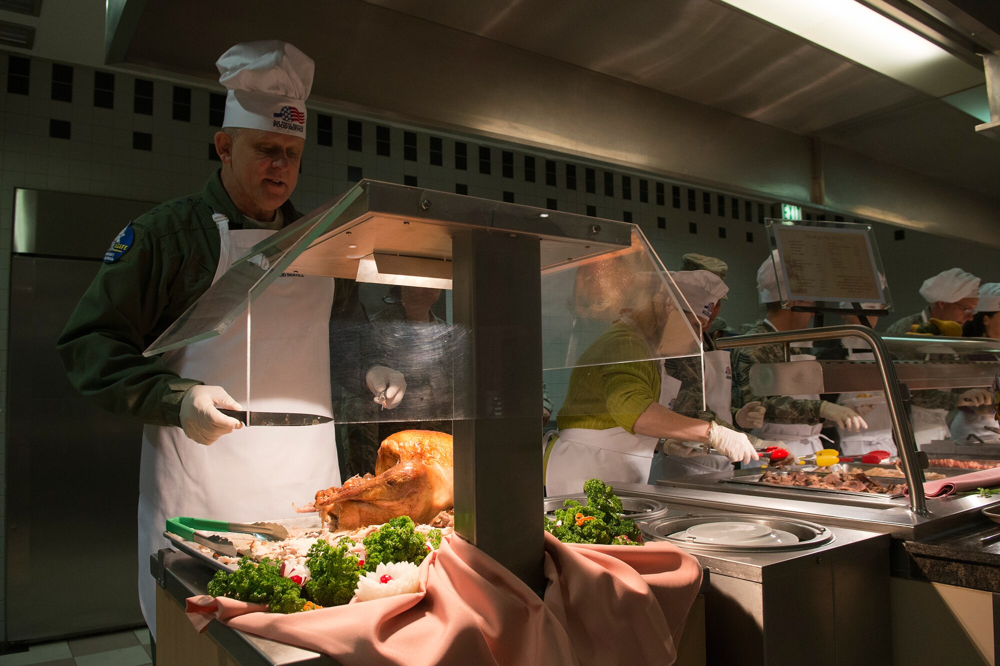 Gen. Frank Gorenc, U.S. Air Forces in Europe and Air Forces Africa commander, prepares to carve turkey in the Rhineland Inn Dining Facility Nov. 28, 2013, Ramstein Air Base, Germany. Leadership gathered to serve a holiday meal to Airmen and families to boost morale and provide a low-cost option. (U.S. Air Force photo/Senior Airman Jose L. Leon)