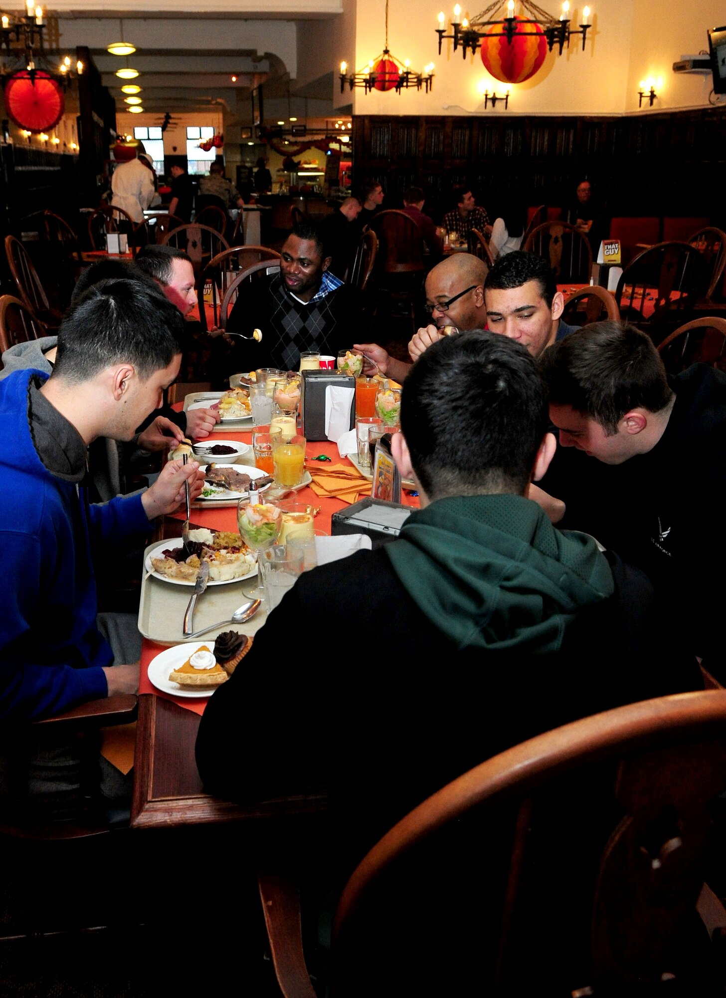 U.S. Air Force Airman 1st Class Yanick Mba, far side of the table, 352nd Special Operations Maintenance Squadron supply liaison, celebrates his first Thanksgiving meal with friends Nov. 28, 2013, at the Gateway Dining Facility on RAF Mildenhall, England. Mba recently joined the U.S. Air Force from Africa where the American holiday isn’t celebrated. (U.S. Air Force photo by Senior Airman Kate Maurer/Released)