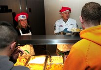 U.S Air Force Chief Master Sgt. Tracy Jones, right, 100th Air Refueling Wing command chief, and Shannon Bibb, wife of U.S. Air Force Col. Kenneth T. Bibb Jr., 100th ARW commander, serve Thanksgiving lunch to patrons in the Gateway Dining Facility Nov. 28, 2013, on RAF Mildenhall, England. Approximately 250 members of Team Mildenhall attended the meal where several distinguished visitors joined the dining facility staff to serve lunch in celebration of the American holiday. (U.S. Air Force photo by Senior Airman Kate Maurer/Released)