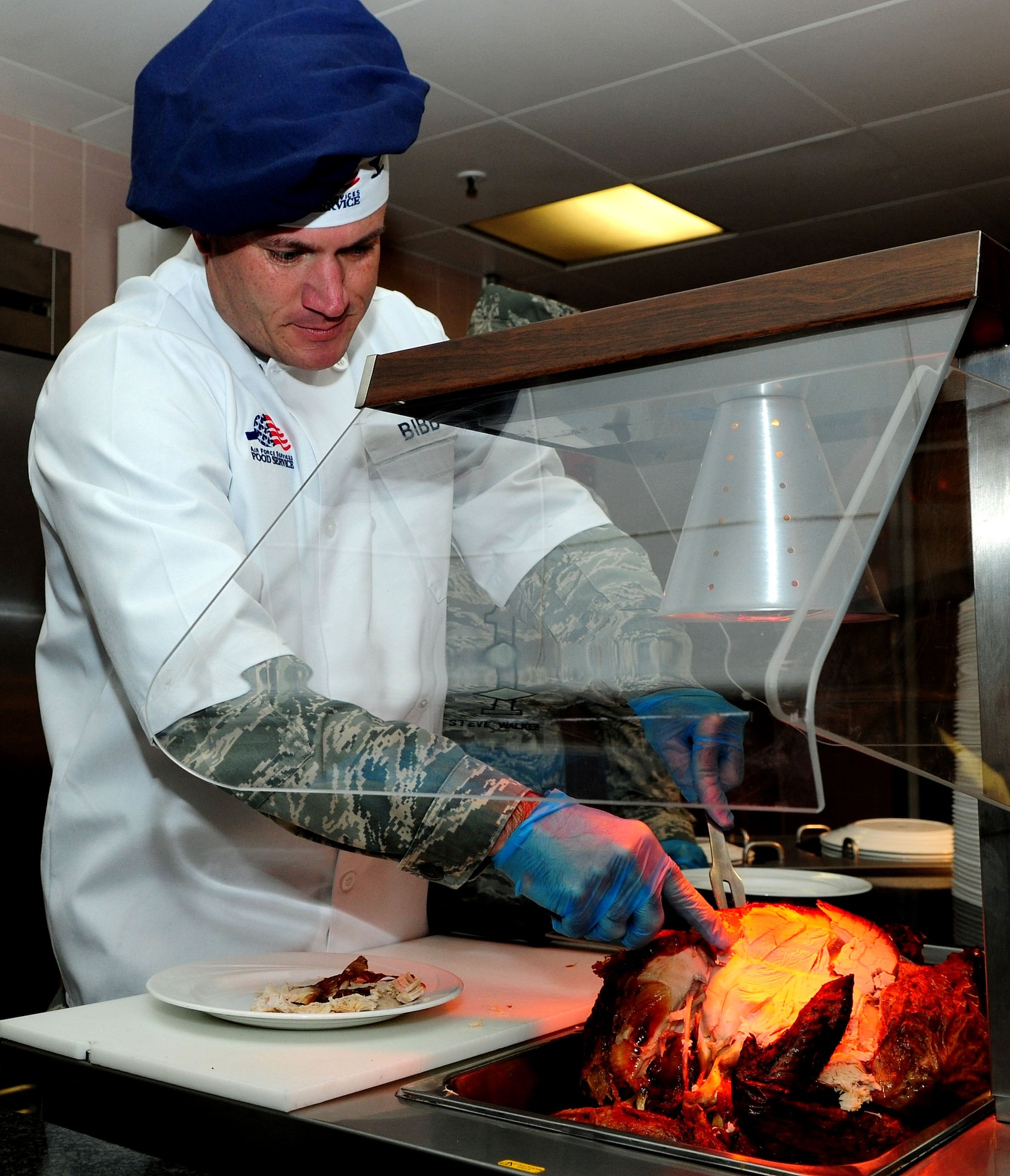 U.S. Air Force Col. Kenneth T. Bibb Jr., 100th Air Refueling Wing commander, carves a turkey during the Thanksgiving lunch served in celebration of the American holiday Nov. 28, 2013, at the Gateway Dining Facility on RAF Mildenhall, England. Several distinguished visitors joined the dining facility staff to serve lunch to approximately 250 members of Team Mildenhall. (U.S. Air Force photo by Senior Airman Kate Maurer/Released)