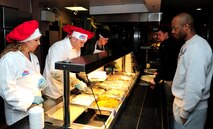 U.S. Air Force Brig. Gen. Christopher J. Bence, second from left, director to U.S. Air Forces in Europe-United Kingdom, and his wife Wendy, left, serve Thanksgiving lunch to patrons in the Gateway Dining Facility Nov. 28, 2013, on RAF Mildenhall, England. Several distinguished visitors joined the dining facility staff to serve lunch to approximately 250 members of Team Mildenhall in celebration of the American holiday. (U.S. Air Force photo by Senior Airman Kate Maurer/Released)