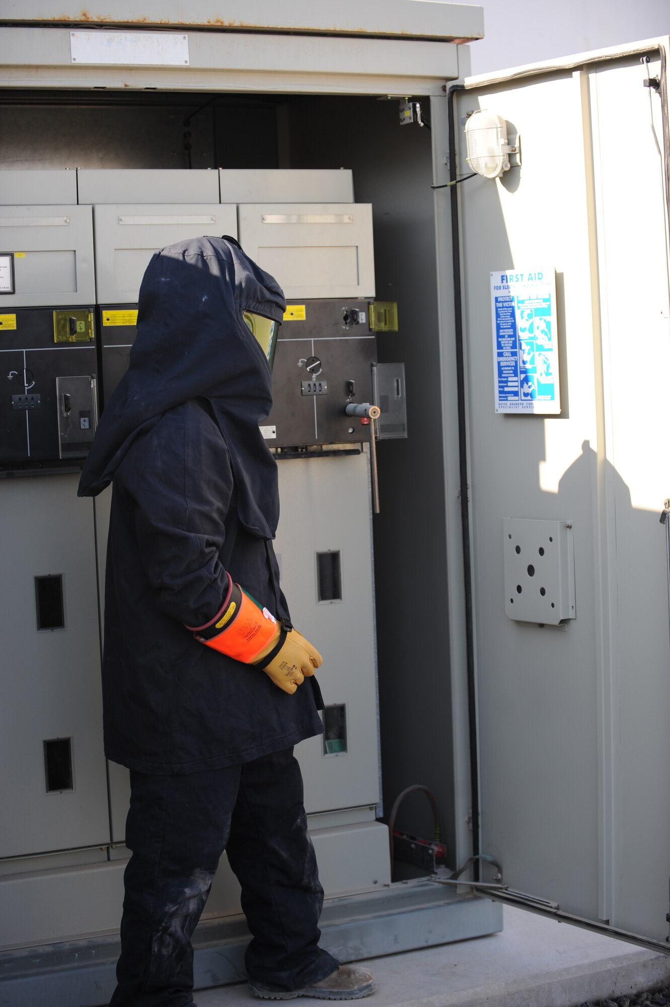 U.S. Air Force Airman 1st Class Scott Baxley, 380th Expeditionary Civil Engineer Squadron electrical systems technician, gets ready to return power to a power distribution center at an undisclosed location in Southwest Asia Nov. 23, 2013. When power is live, electrical systems technicians are required to wear an arc flash suit due to the possibility of an electrical arc flash occurring. The problem with this generator was discovered after a minor flood. Baxley calls Bladenboro, N.C., home and is deployed from Barksdale Air Force Base, La. (U.S. Air Force photo by Staff Sgt. Jacob Morgan) 