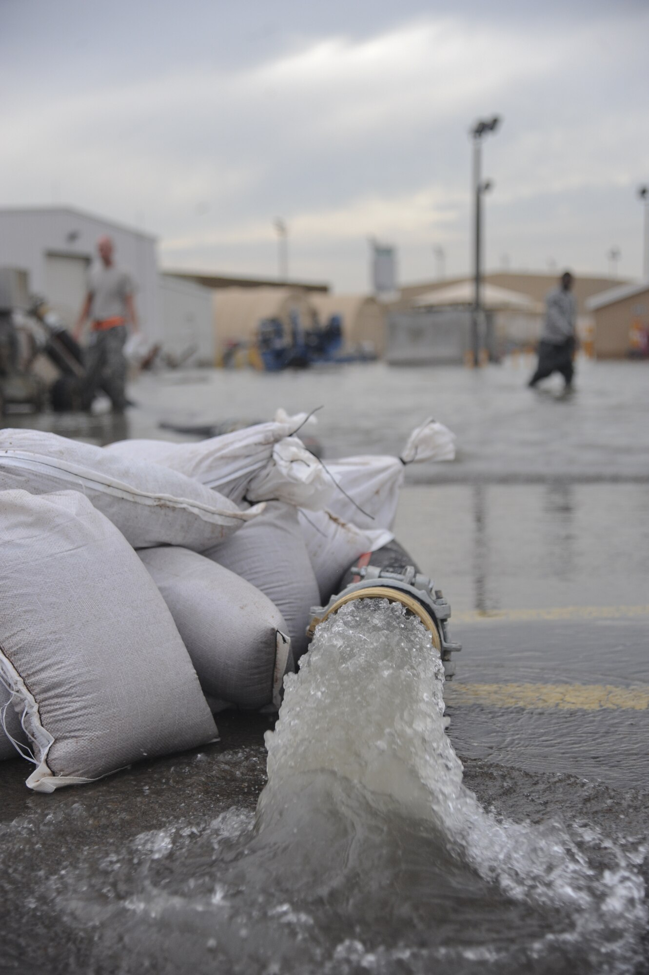 Water rushes from a hose after being sucked through a water pump at an undisclosed location in Southwest Asia Nov. 21, 2013. After an inch of rain, some low areas on base experienced minor flooding. Several specialties from the 380th Expeditionary Civil Engineer Squadron were on site and quickly returned the base to normal operations. (U.S. Air Force photo by Staff Sgt. Jacob Morgan)