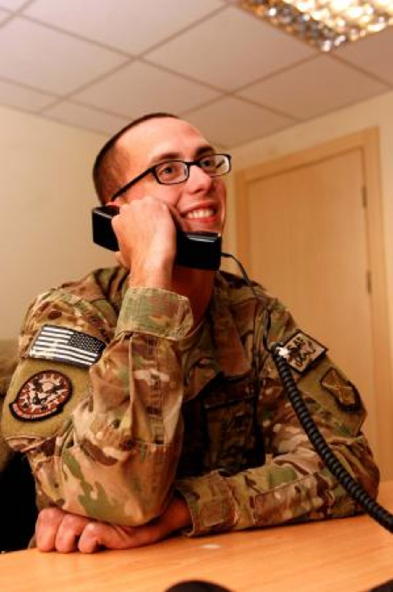 Afghanistan-deployed Staff Sgt. Dustin Hawkins talks to President Barack Obama on the phone Nov. 28, 2013, at Kandahar Airfield. The president thanked Hawkins for his service and talked football with him. Hawkins is assigned to the with the 451st Expeditionary Civil Engineer Squadron and deployed from Mountain Home Air Force Base, Idaho. (U.S. Air Force photo/Senior Airman Jack Sanders)