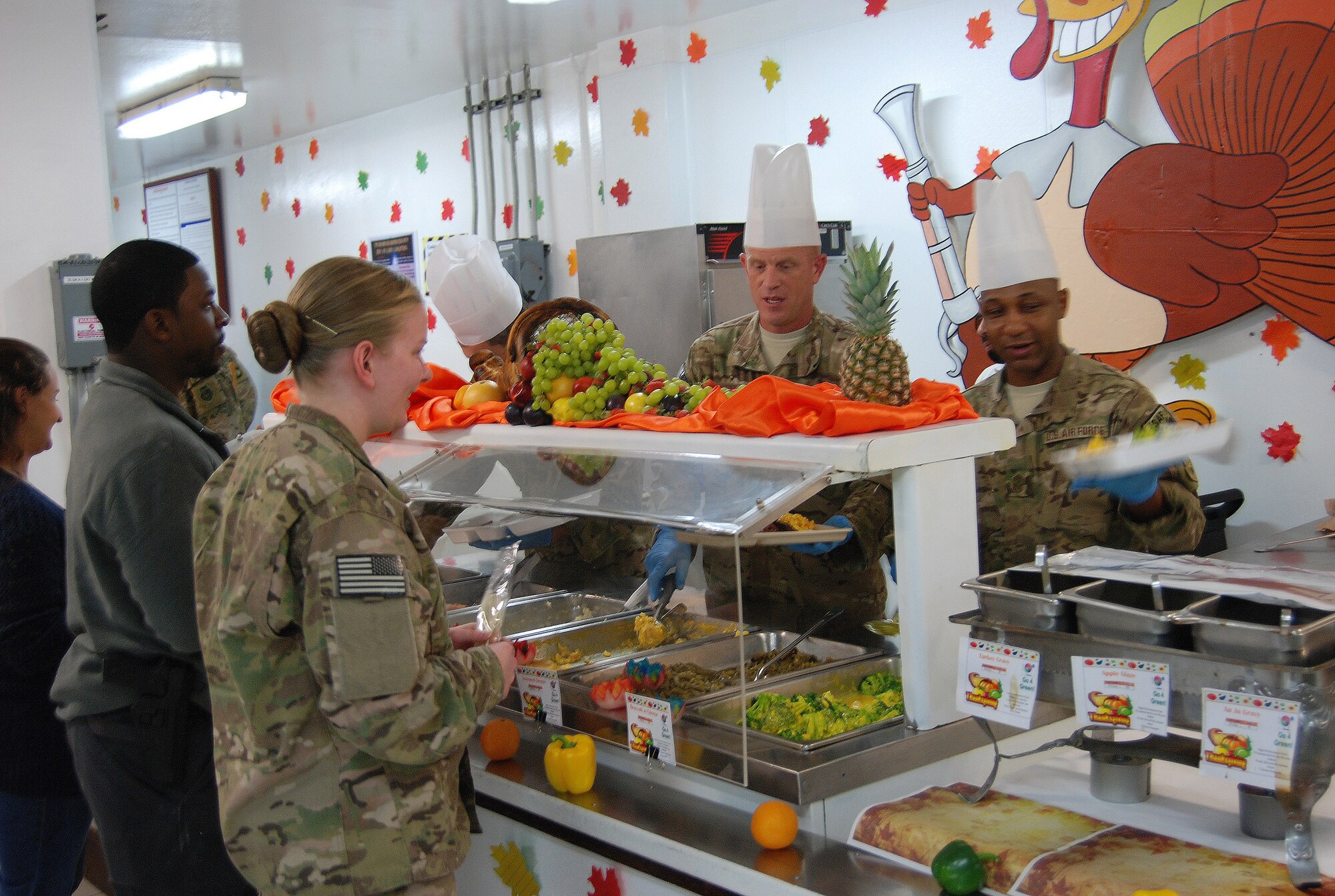 Chief Master Sergeant Frank Batten III, 9th Air and Space Expeditionary Task Force- Afghanistan command chief (middle) and Chief Master Sgt. Kenneth Lindsey, Command Chief Master Sergeant of the 455th Air Expeditionary Wing, serve Thanksgiving dinner to service members at the Dragon DFAC here, November 28, 2013. Various senior leaders took shifts serving dinner to service members, civilians and contractors at Bagram Airfield, Afghanistan. (U.S. Air Force Photo by Capt. Brian Wagner)