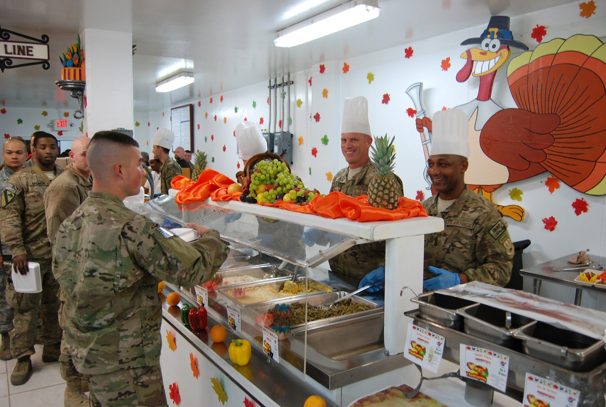 Chief Master Sergeant Frank Batten III, 9th Air and Space Expeditionary Task Force- Afghanistan command chief (middle) and Chief Master Sgt. Kenneth Lindsey, Command Chief Master Sergeant of the 455th Air Expeditionary Wing, serve Thanksgiving dinner to service members at the Dragon DFAC here, November 28, 2013. Various senior leaders took shifts serving dinner to service members, civilians and contractors at Bagram Airfield, Afghanistan.