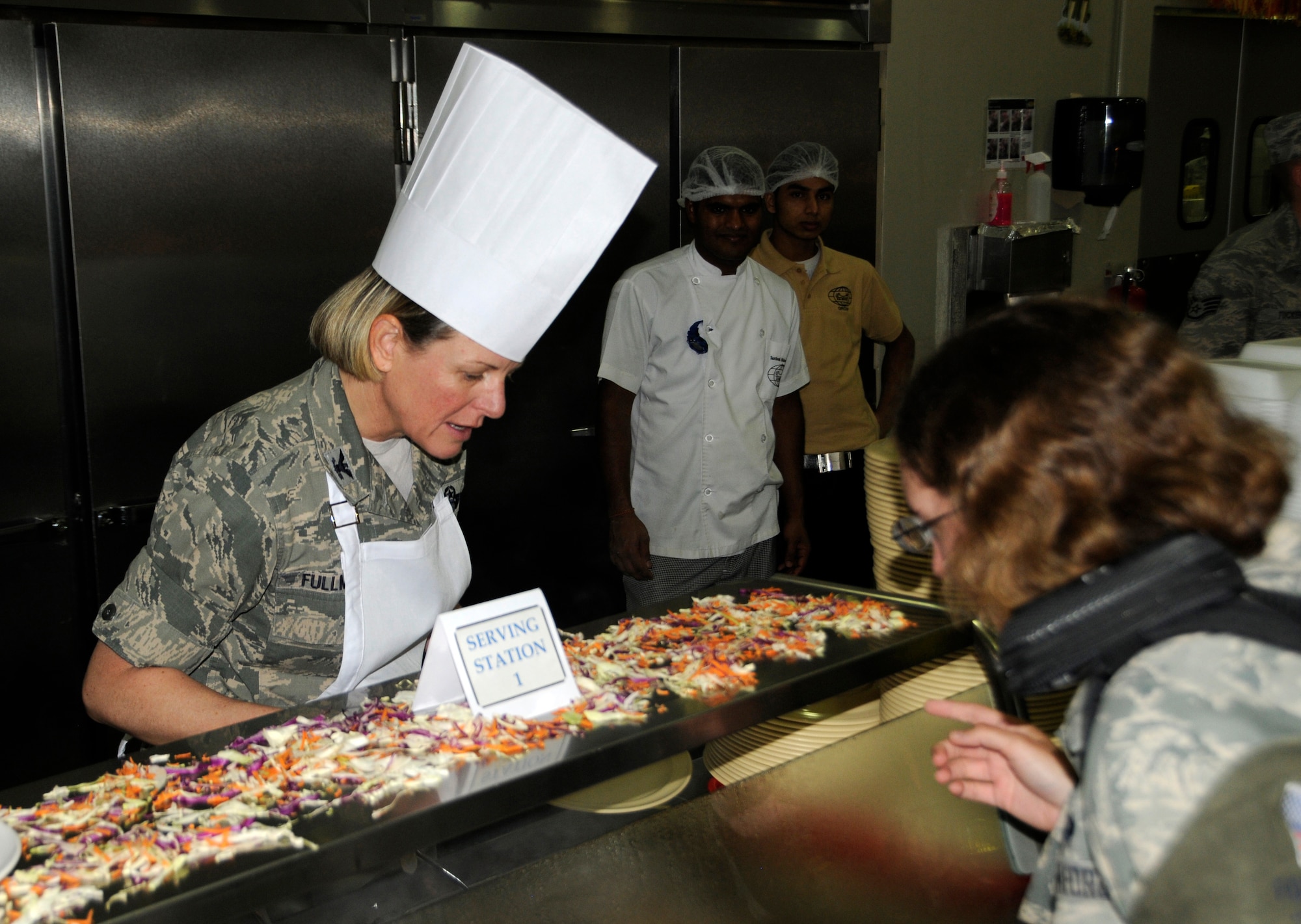 Col. Jennifer Fullmer serves a plate of turkey to an Airman during Thanksgiving Day meal at the 379th Air Expeditionary Wing in Southwest Asia, Nov. 28, 2013. Senior leadership volunteered throughout the day to serve meals to service members at the base dining facilities. Fullmer is the 379th AEW vice commander assigned here and hails here from Wilton, Conn. (U.S. Air Force photo/Senior Airman Hannah Landeros)